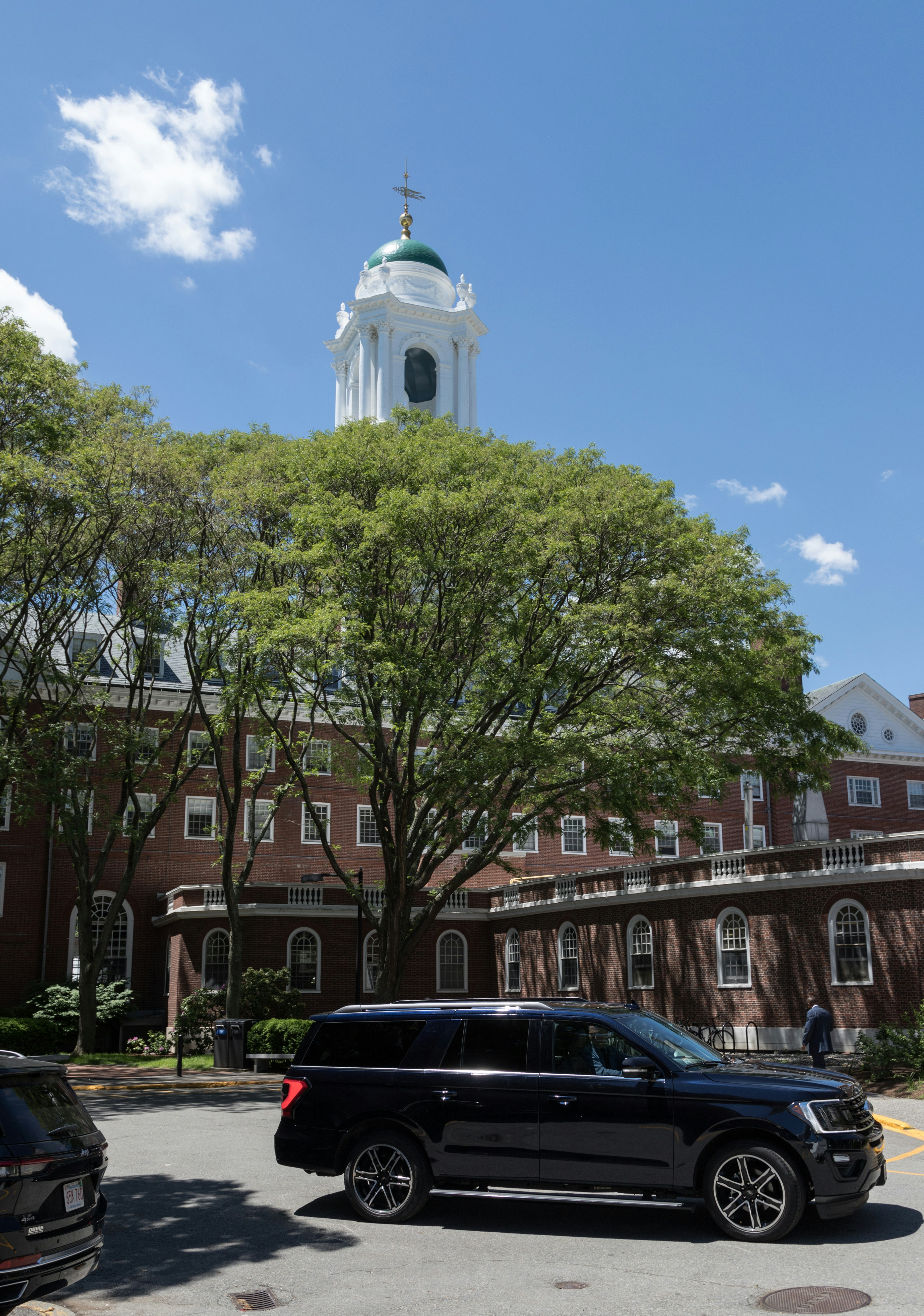 a black car parked in front of a large brick building